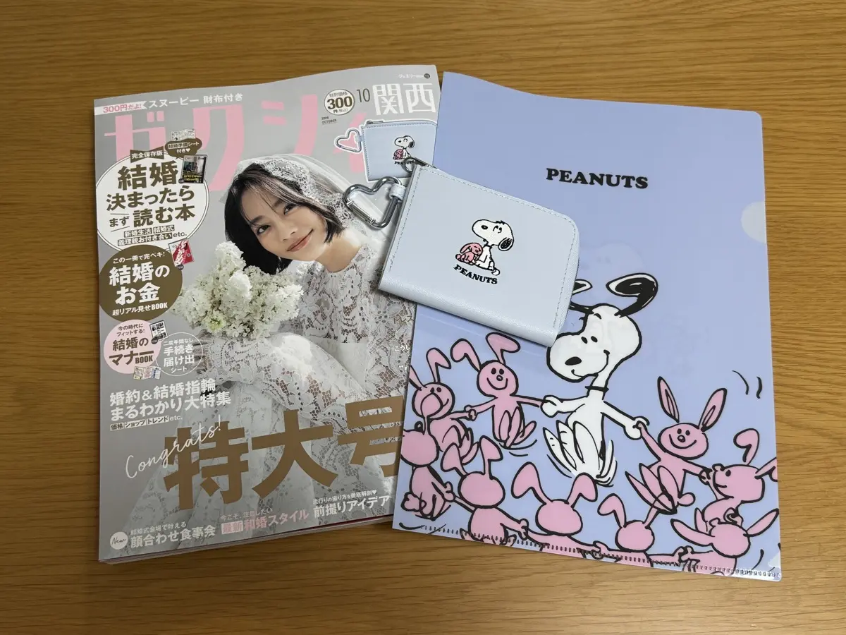 ゼクシィ2026年10月号の実物。付録のスヌーピーミニ財布とPEANUTSクリアファイル